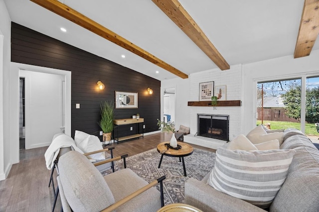 living area with wood walls, a fireplace, wood finished floors, and baseboards