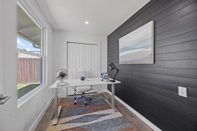 home office with wood walls, baseboards, and wood finished floors