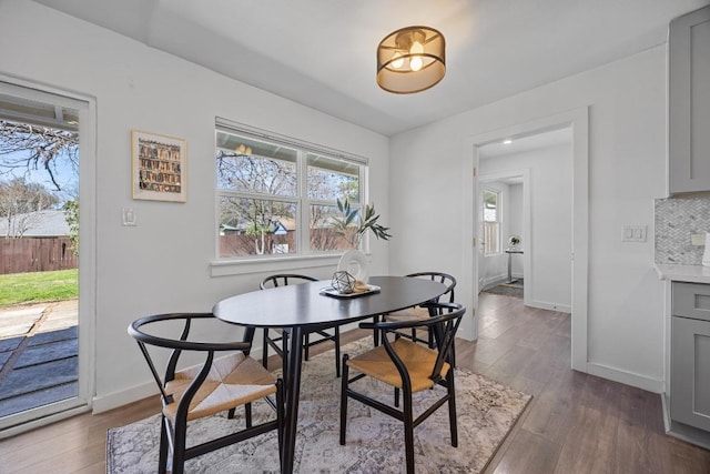 dining area featuring baseboards and dark wood-type flooring