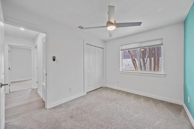 unfurnished bedroom featuring a ceiling fan, a closet, carpet flooring, and baseboards