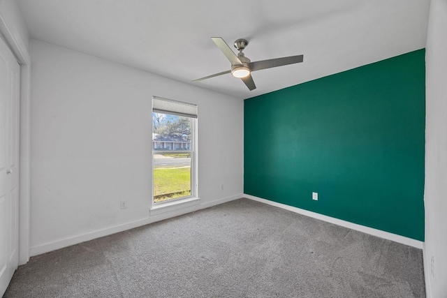 unfurnished room featuring carpet, ceiling fan, and baseboards