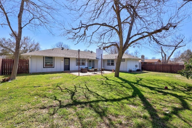 rear view of property with a patio, a yard, board and batten siding, and fence