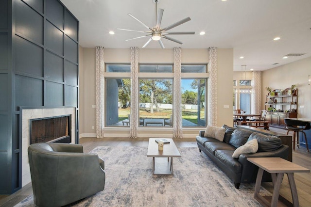 living area featuring a large fireplace, wood finished floors, and recessed lighting