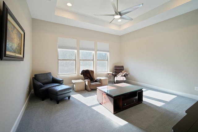 sitting room featuring a tray ceiling, recessed lighting, carpet flooring, and baseboards