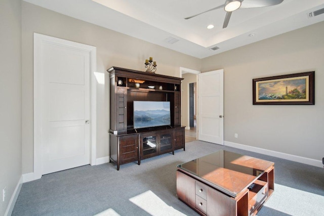 carpeted living room featuring baseboards, visible vents, a ceiling fan, a tray ceiling, and recessed lighting