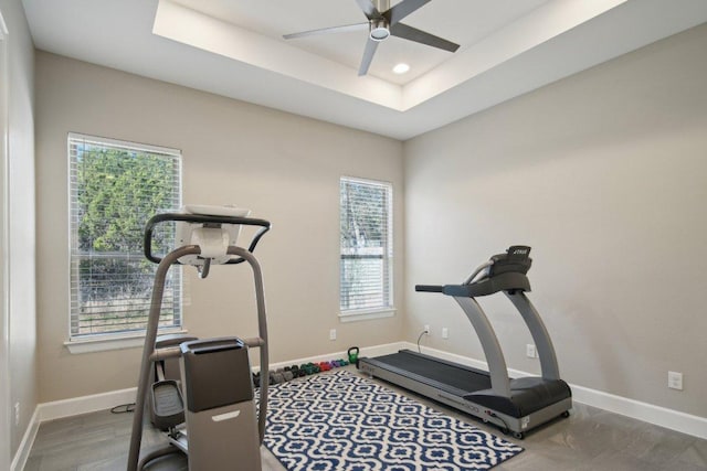 workout room featuring baseboards, a raised ceiling, a ceiling fan, and recessed lighting