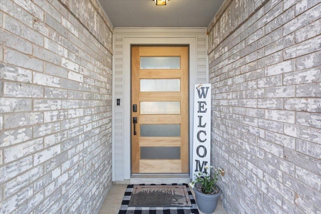 property entrance featuring brick siding