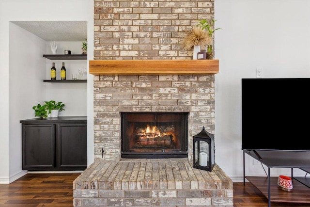 interior details with a fireplace, wood finished floors, and baseboards