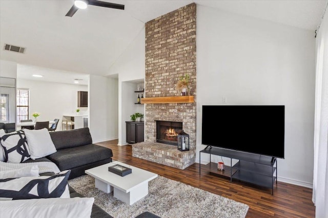 living room featuring high vaulted ceiling, baseboards, visible vents, and wood finished floors