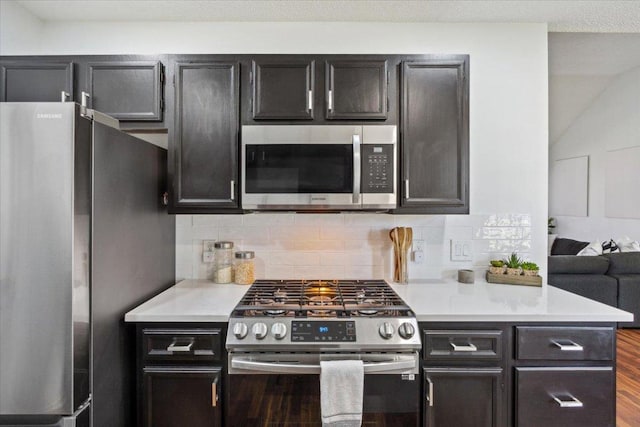 kitchen featuring appliances with stainless steel finishes, light countertops, and backsplash