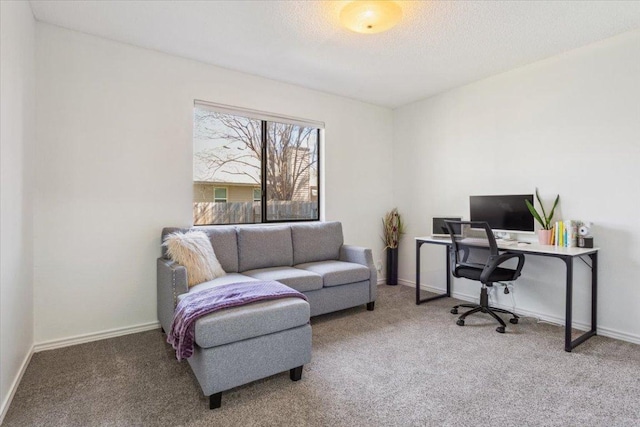 carpeted office space featuring a textured ceiling and baseboards