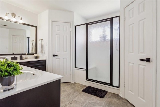 bathroom with a shower stall and vanity