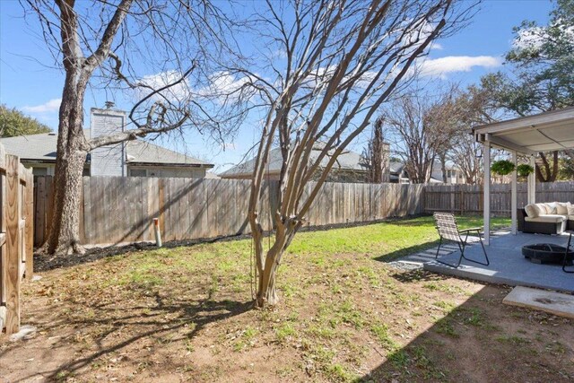 view of yard with a patio area, a fenced backyard, and a fire pit