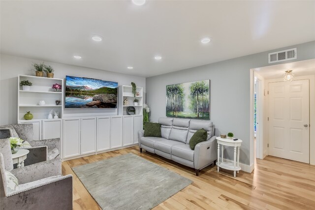 living area featuring light wood-type flooring, visible vents, and recessed lighting