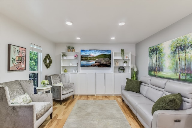 living room with light wood-type flooring and recessed lighting