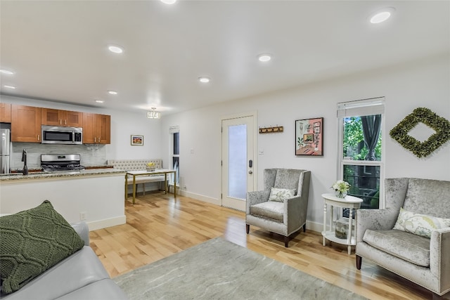 living room featuring baseboards, light wood-style flooring, and recessed lighting