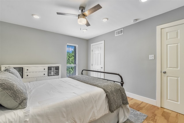 bedroom featuring light wood-type flooring, baseboards, visible vents, and ceiling fan