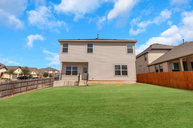 back of property featuring a fenced backyard and a lawn