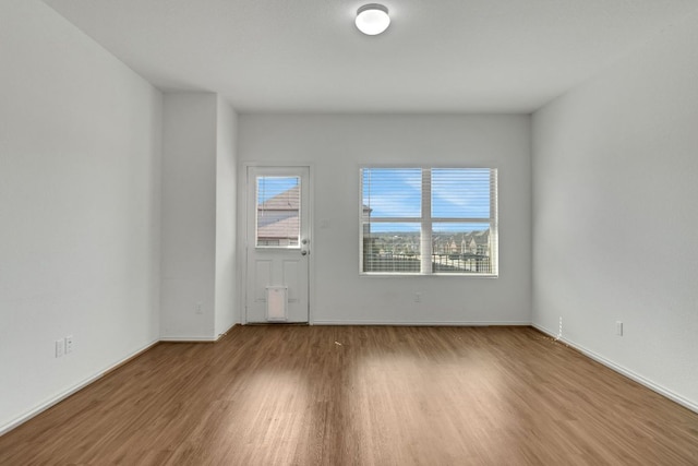 unfurnished room with wood finished floors and baseboards