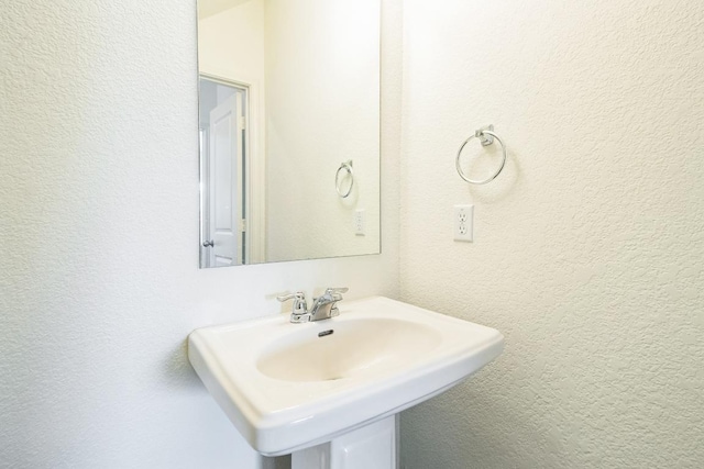 bathroom with a sink and a textured wall