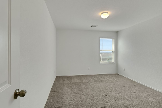 unfurnished room featuring carpet flooring, visible vents, and baseboards