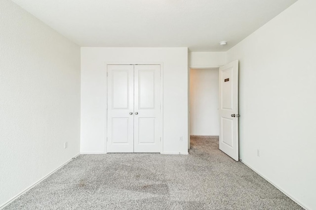 unfurnished bedroom featuring carpet floors and a closet