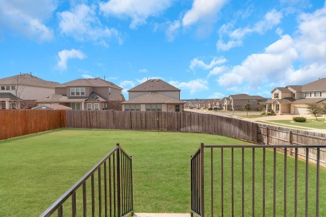 view of yard with a fenced backyard and a residential view