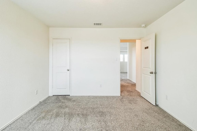 carpeted spare room featuring visible vents