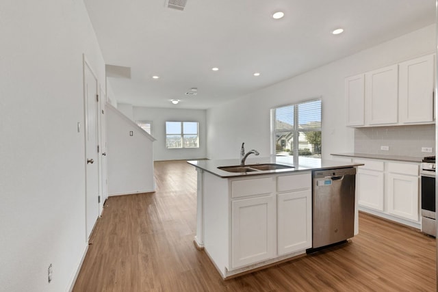 kitchen featuring appliances with stainless steel finishes, backsplash, a sink, and light wood-style flooring