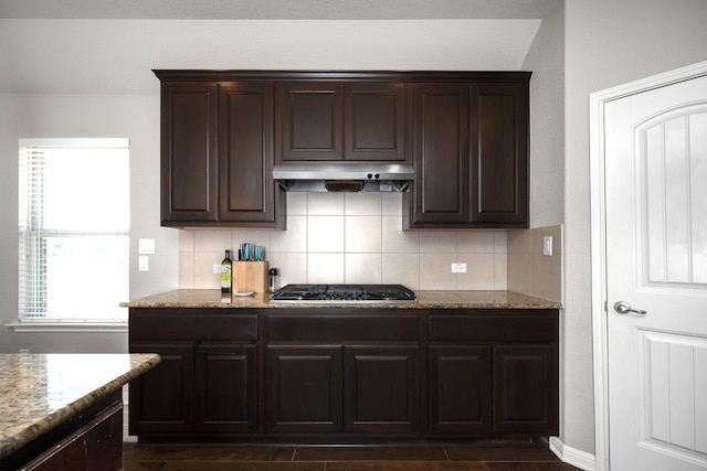 kitchen featuring stainless steel gas stovetop, tasteful backsplash, dark brown cabinets, and under cabinet range hood