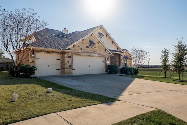 view of front of home featuring driveway, stone siding, a chimney, an attached garage, and a front lawn