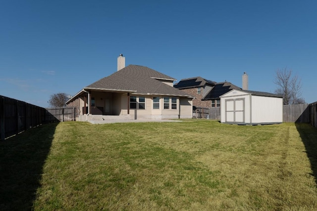 rear view of house with an outbuilding, a patio, a fenced backyard, a storage shed, and a lawn