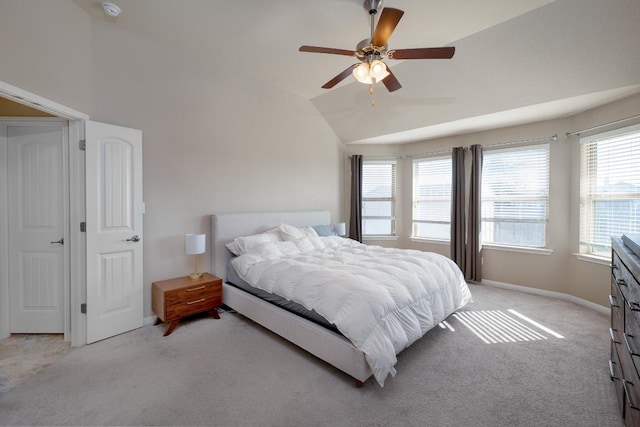 bedroom with light carpet, vaulted ceiling, a ceiling fan, and baseboards