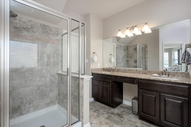 full bath with a stall shower, a sink, and double vanity