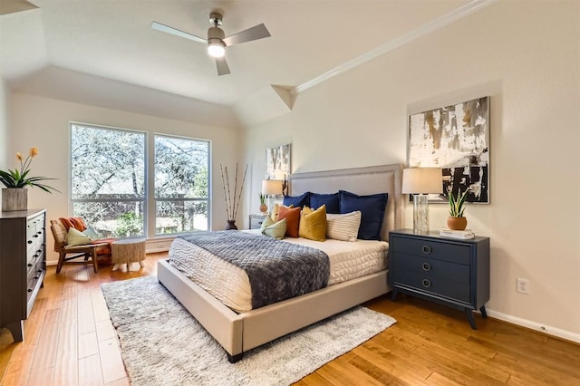 bedroom with crown molding, a ceiling fan, light wood-style flooring, and baseboards