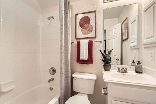 bathroom with a textured wall, shower / tub combo with curtain, vanity, and toilet