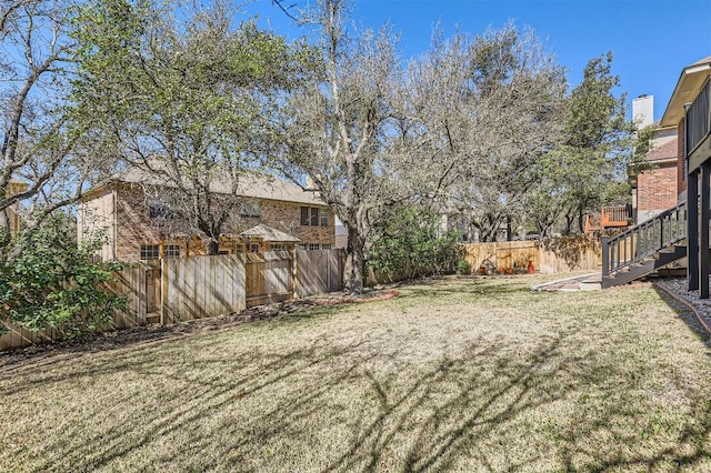 view of yard featuring a fenced backyard and stairway