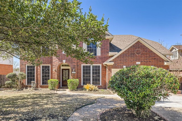 view of front of house with a garage, a shingled roof, fence, and brick siding