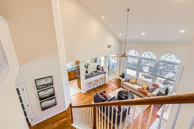 living area with light wood finished floors, visible vents, a ceiling fan, high vaulted ceiling, and recessed lighting