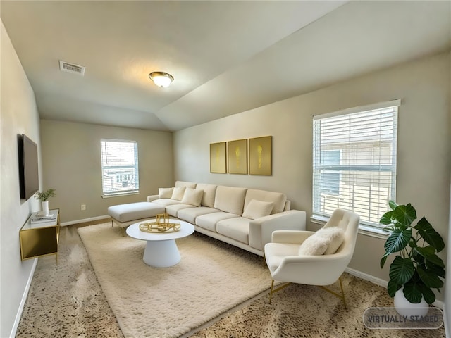 living area featuring lofted ceiling, baseboards, and visible vents