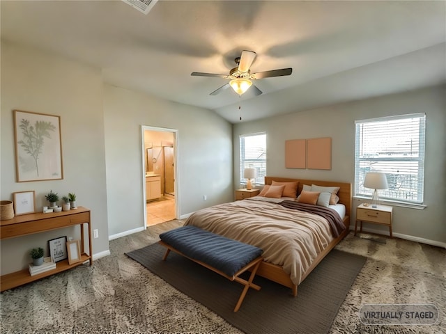 bedroom with carpet floors, connected bathroom, vaulted ceiling, and baseboards