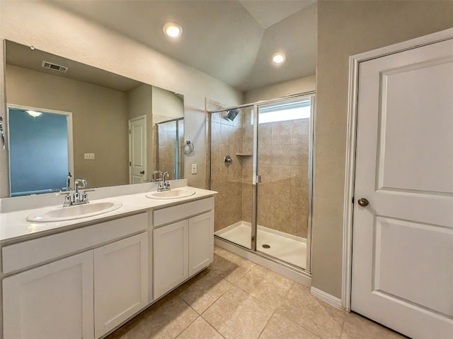 bathroom with visible vents, a sink, a shower stall, and tile patterned floors