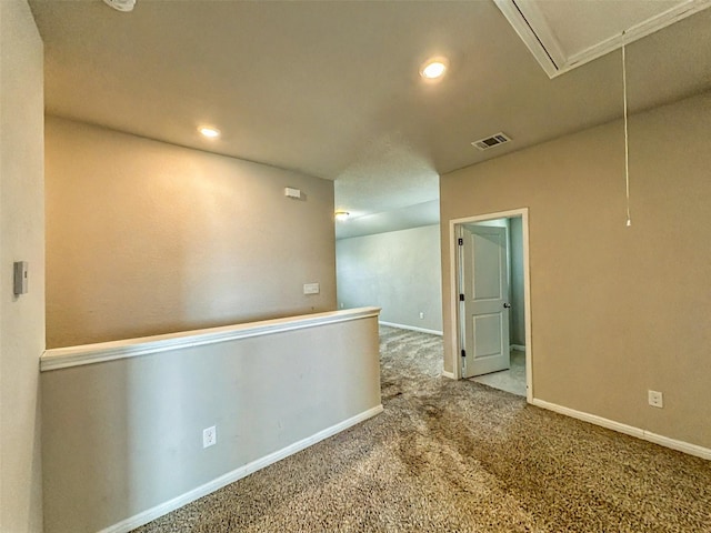 spare room with carpet, recessed lighting, visible vents, attic access, and baseboards