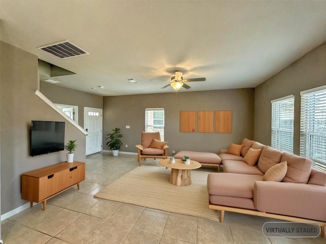 living room featuring a healthy amount of sunlight, visible vents, ceiling fan, and baseboards