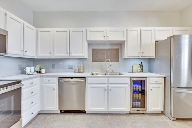 kitchen featuring stainless steel appliances, beverage cooler, a sink, and tasteful backsplash