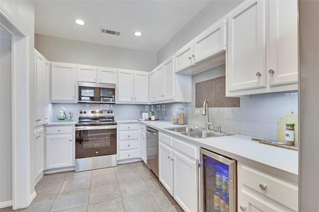 kitchen with wine cooler, light countertops, visible vents, appliances with stainless steel finishes, and a sink