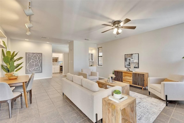 tiled living room with rail lighting, baseboards, visible vents, and a ceiling fan