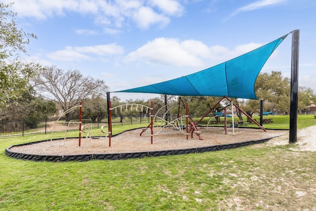 community jungle gym featuring fence and a lawn