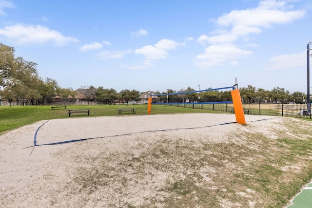 view of community with volleyball court, a yard, and fence