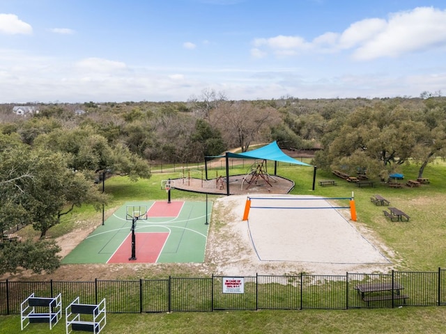 view of basketball court featuring community basketball court, fence, a view of trees, and a lawn